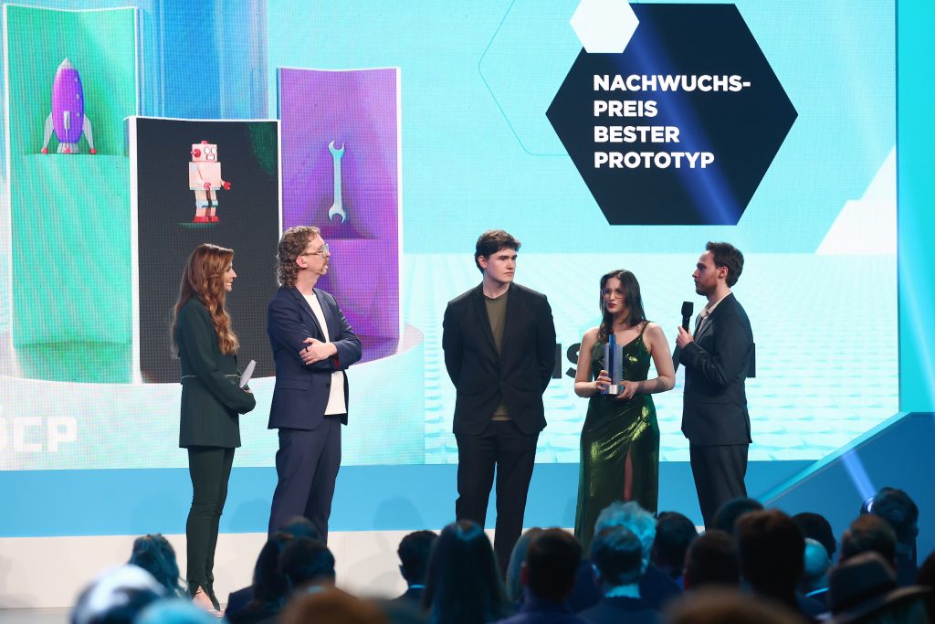 MUNICH, GERMANY - APRIL 18: Hosts Katrin Bauernfeind, Uke Bosse and "Symmetry Break Studio" with "Misgiven", winner of the "Up-And-Coming Best Prototype" award, speak on stage during the annual German Computer Game Award (Der Deutsche Computerspielpreis) at Eisbach Studios on April 18, 2024 in Munich, Germany. (Photo by Sebastian Reuter/Getty Images for Marchsreiter Communications)